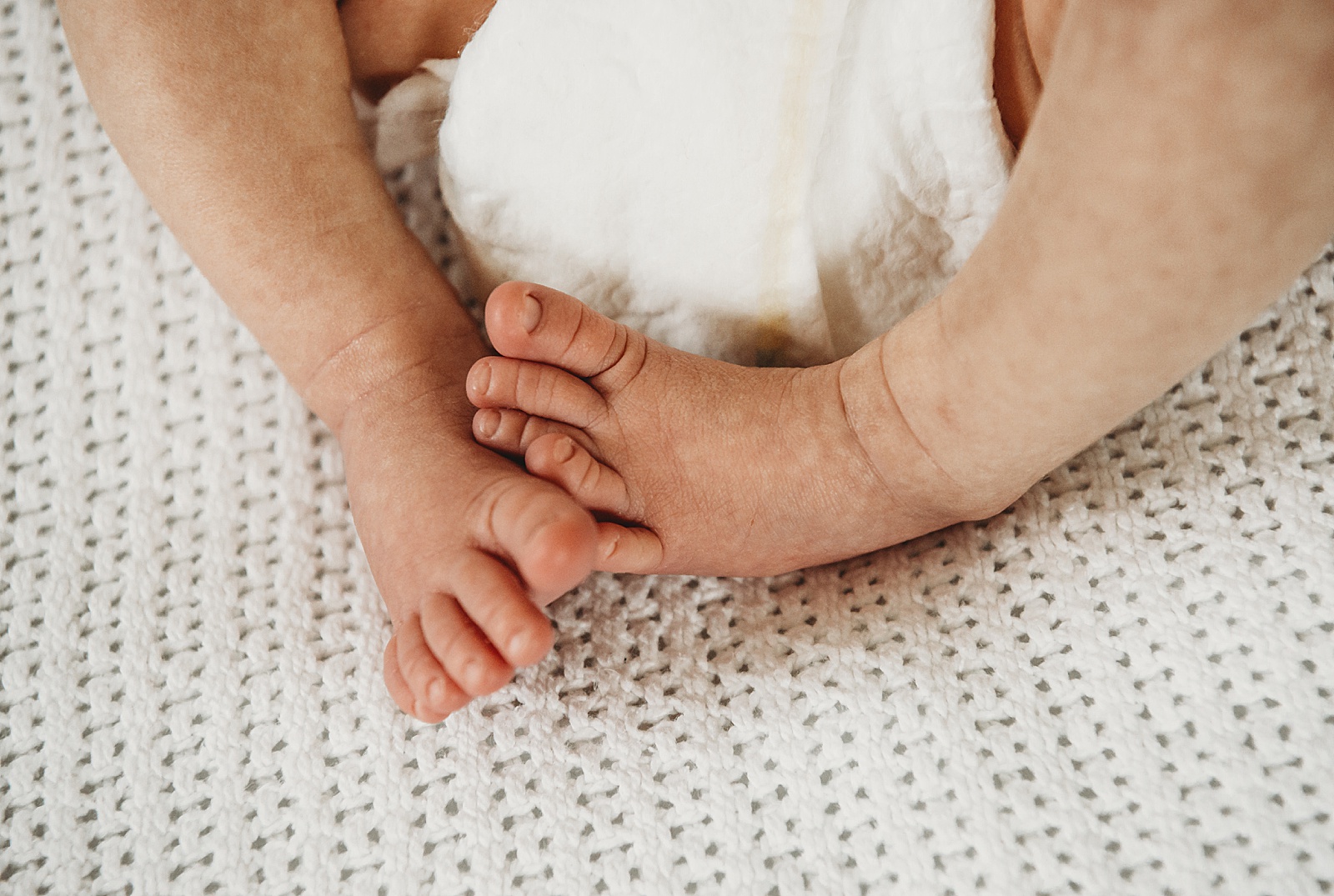 A closeup photo shows a newborn baby's feet.