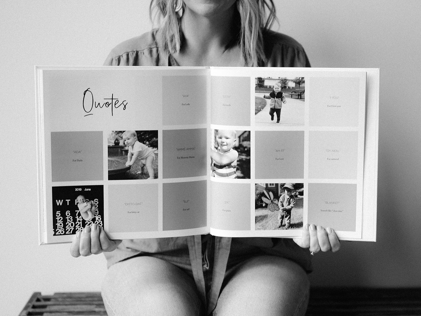 A woman holds up a quotes page from a toddler memory book.