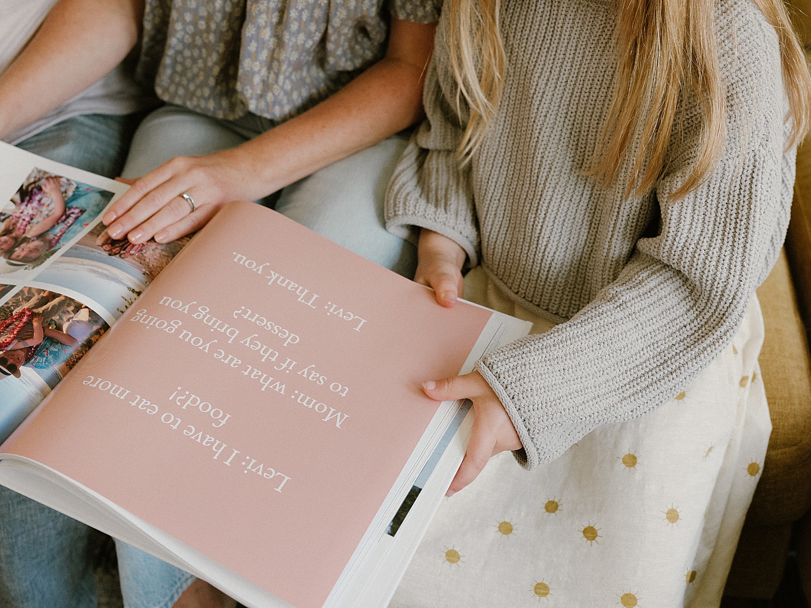 A mother and child flip through a memory book together.