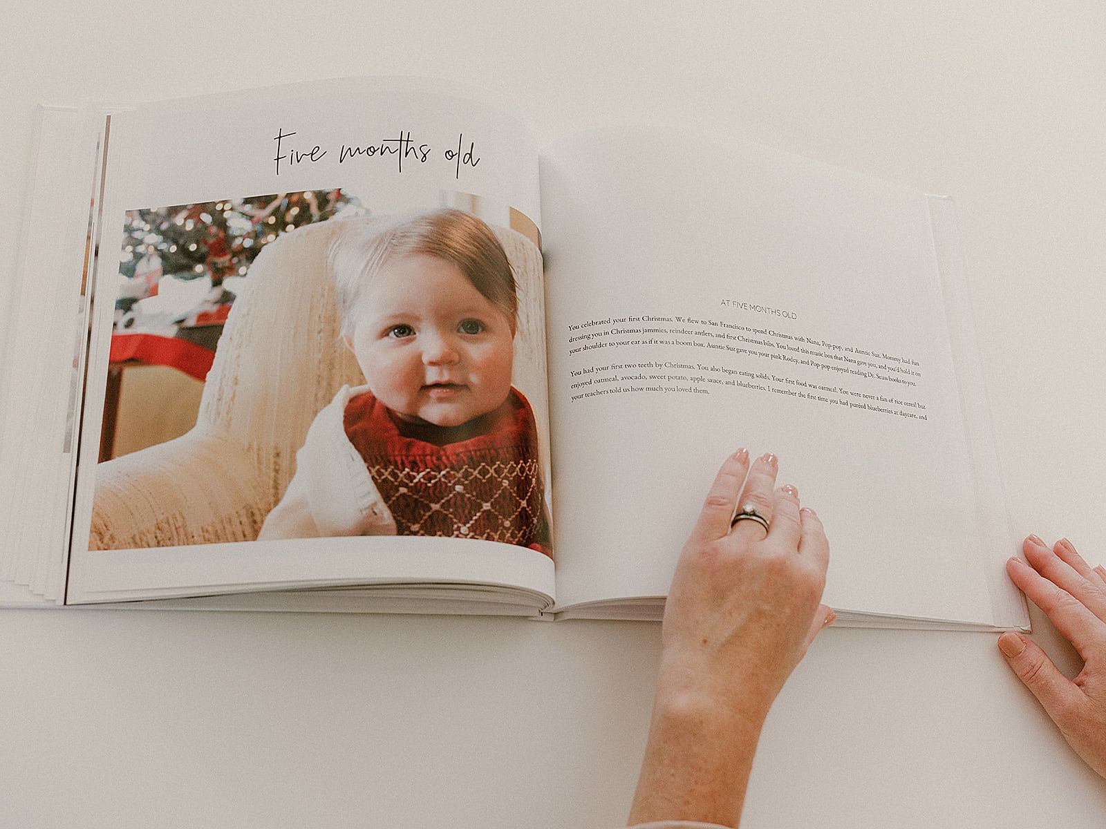 A photo book for baby is opened to a page with a story beside a photo.