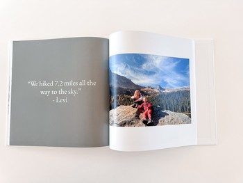 A family photo album is open to a layout with a photo and quote page.